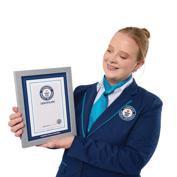 female adjudcator in a Guinness World Records blue uniform holding a framed record participate certificate